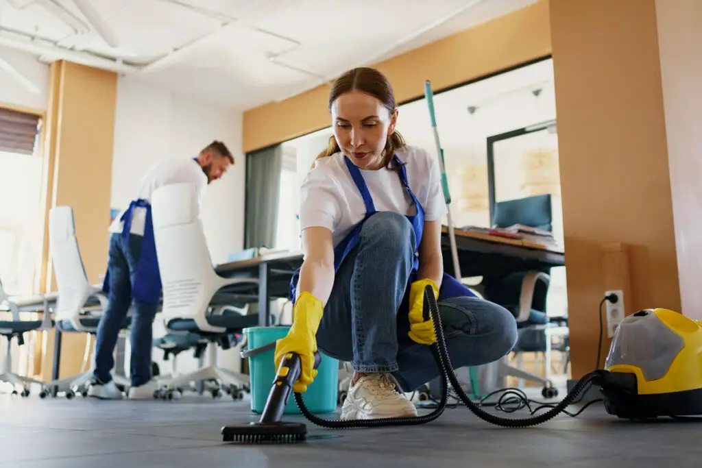 Professional team performing office cleaning in a modern workspace.