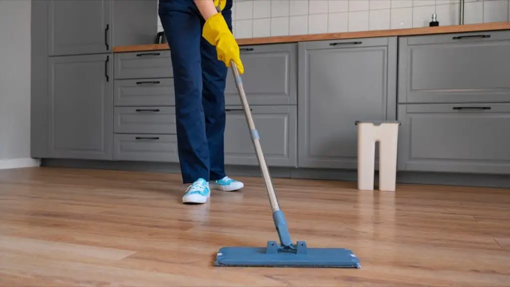 Cleaner mopping kitchen floor with flat mop